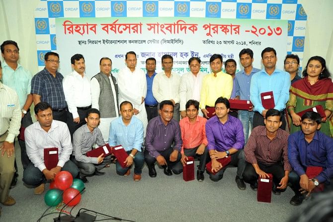 Hasanul Haq Inu, information minister, and Alamgir Shamsul Alamin, president of Real Estate and Housing Association of Bangladesh, pose with the reporters awarded for their coverage of the real estate sector, at a programme at Cirdap auditorium in Dhaka yesterday. Photo: Star