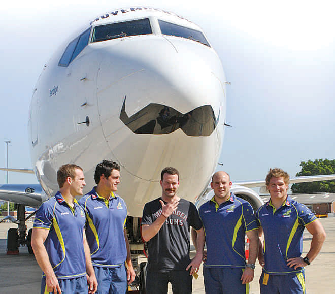 Some members of Australia  national rugby union team  stands before a promotionally  decorated Boeing 737-800  aircraft during Movember in 2011. 