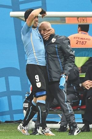 After scoring the opener, Luis Suarez ran straight to the bench and hugged Walter Ferreira, the man who got him fit in less than four weeks after a knee surgery.  PHOTO: AFP