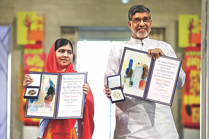Nobel Peace Prize laureates Kailash Satyarthi (R) and Malala Yousafzai display their medals and diplomas during the Nobel Peace Prize awards ceremony. Photo: AFP