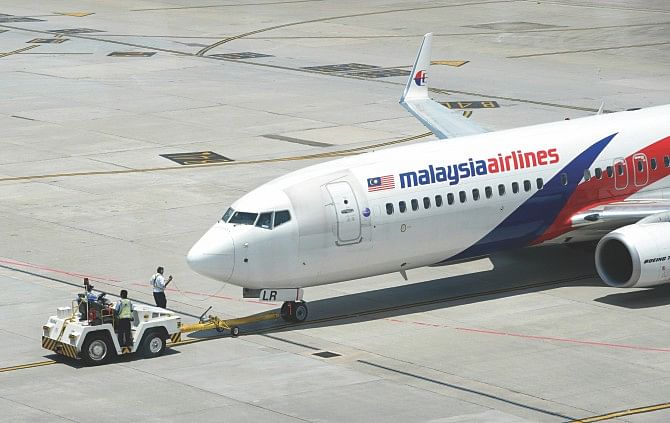 Ground staff tow out a Malaysia Airlines plane from the terminal at Kuala Lumpur International Airport in Sepang. Photo: AFP/File