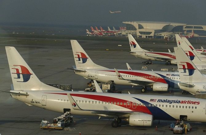 Ground crew work among Malaysia Airlines planes on the runway at Kuala Lumpur International Airport in Sepang, Malaysia. Photo: Reuters