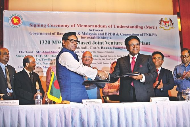 Nasrul Hamid, state minister for power, and Samy Vellu, a special envoy of the Malaysian prime minister, shake hands after signing a memorandum of understanding at Sonargaon Hotel in Dhaka yesterday to set up a coal power plant. AMA Muhith, finance minister, was also present. Photo: Star 