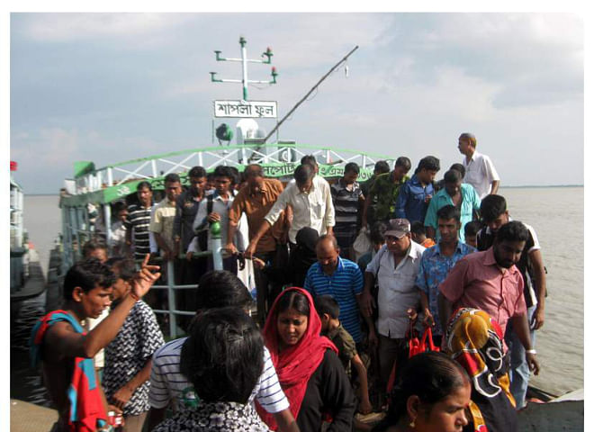 Launches plying Paturia-Daulatdia route carry passengers beyond their usual capacity, much to the risk of accidents during the ongoing monsoon. Photo shows the launch, Shapla, arrives at Patuaria terminal from Daulatdia on Friday with 210 passengers though its usual capacity is 129 passengers.  Photo: Star