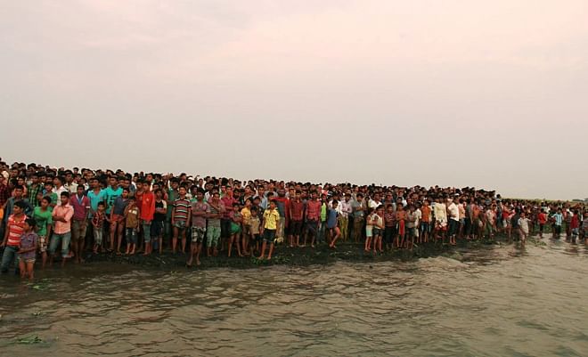 A crowd gathers on the shore of the Meghna at Doulatpur of Gazaria in Munshiganj where a launch went down yesterday afternoon.  Photo: Star
