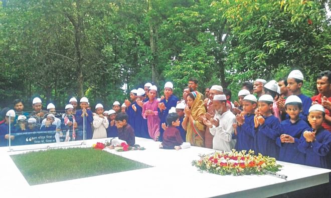 Humayun Ahmed's wife Meher Afroz Shaon and two sons join prayers for his departed soul while fans lay wreaths at his grave in Nuhash Palli on the occasion of his death anniversary yesterday.  Photo: Star