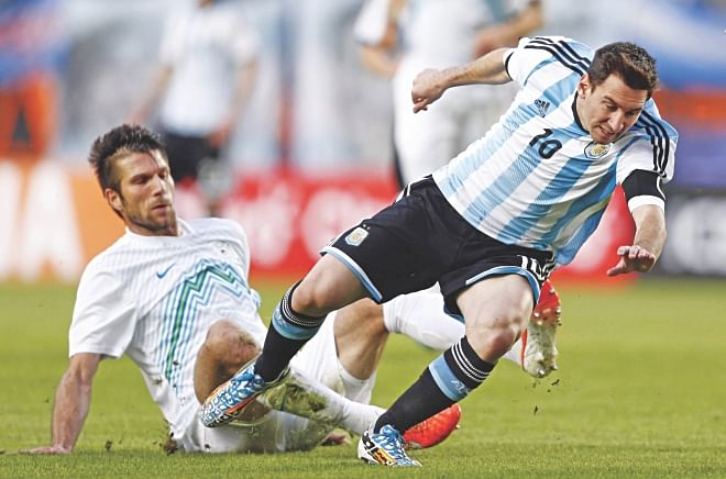 Star Argentina striker Lionel Messi (R) staves off a sliding tackle from Slovenia's Bostjan Cesar during their international friendly in Buenos Aires on Saturday.  PHOTO: AFP