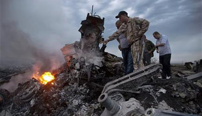 In this July 17 photo, people inspect the crash site of a passenger plane near the village of Grabovo, Ukraine. Photo: AP