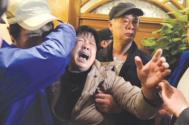 A relative of passengers on Malaysia Airlines flight MH370 cries after hearing yesterday the news that the plane plunged into Indian Ocean. The airline told relatives the plane had been lost and that none on board survived.  PHOTO: AFP