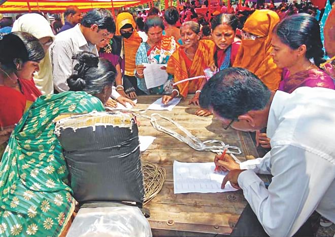 Teachers signing attendance sheets at the venue of a reception programme for State Minister for Fisheries and Livestock Narayan Chandra Chanda at Dumuria of Khulna yesterday. This was done to make sure that teachers of over 200 schools joined the reception programme. Photo: Star