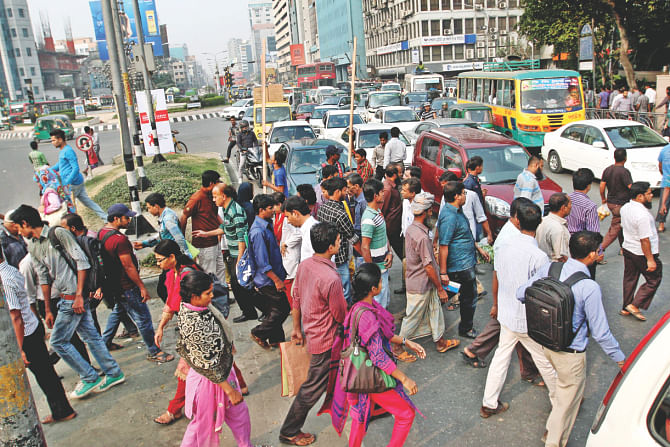 A traffic official (not seen in the photo) stops vehicles and helps people cross the road at Sonargaon intersection. Photo: Anisur Rahman