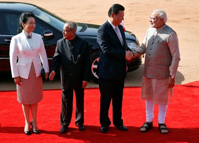 India's Prime Minister Narendra Modi, right, and China's President Xi Jinping, second from right, shake hands as Xi's wife Peng Liyuan and India's President Pranab Mukherjee, second from left, look on during Xi's ceremonial reception at the Rashtrapati Bhavan presidential palace yesterday. Photo: Reuters