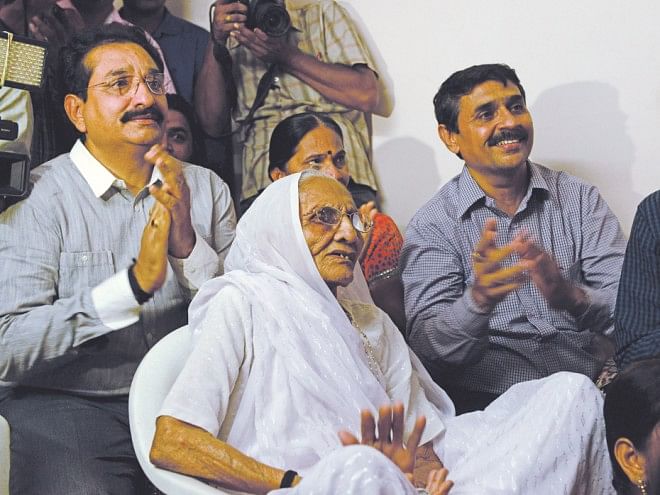 Hira Ba (C), 95, the mother of new Indian Prime Minister Narendra Modi, watches the live broadcast of the swearing-in ceremony of her son with Narendra Modi's brother Pankaj Modi (L) and other relatives from her residence in Gandhinagar. Photo: AFP