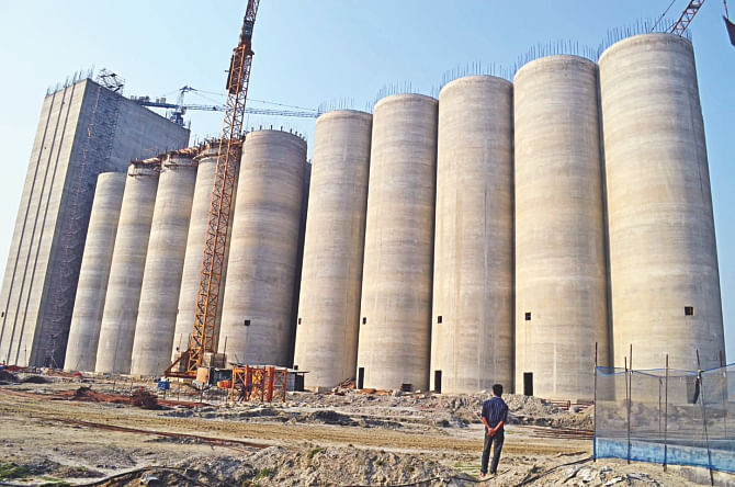 A man looks at the 50,000-tonne grain silo under construction in Joymony village on the bank of the Pashur River in Mongla. Almost 65 percent work is complete.  Photo: Star
