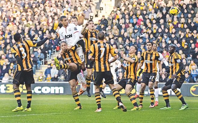 Manchester United defender Chris Smalling (C) heads in his side's first goal against Hull City during their Premier League encounter at the KC Stadium yesterday. Photo: Reuters
