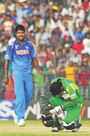 Mushfiqur Rahim is in agony after being struck on the chest by a Varun Aaron (L) beamer at Fatullah yesterday. Photo: Star 