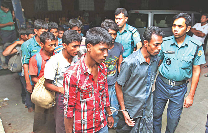 Myanmar nationals, rescued from a trawler heading for Malaysia in the Bay on Monday, being taken to the Chittagong Chief Metropolitan Magistrate's Court yesterday in a case filed against them for intruding into Bangladesh.  Photo: Anurup Kanti Das