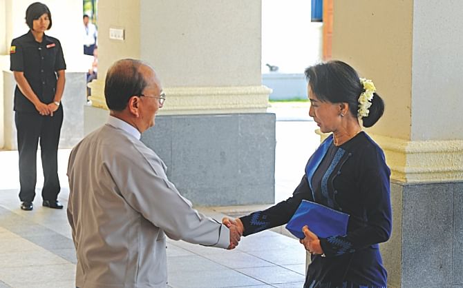 Myanmar President Thein Sein shakes hands with Aung San Suu Kyi prior to their meeting at persident resident office in Naypyidaw, yesterday.  Photo: AFP