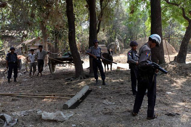 Myanmar policemen stand guard to provide security as they patrol in a village in Okpo township, Bago Region, about 120 miles from Yangon in Myanmar on March.28, 2013. Photo: AP