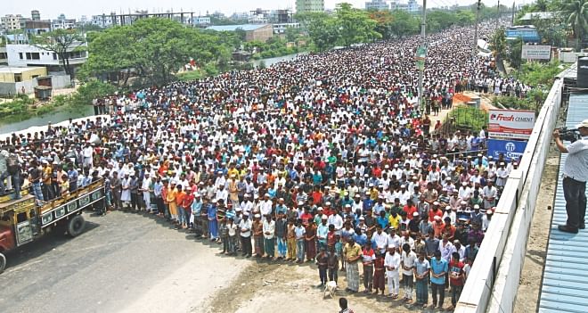 Thousands join the namaz-e-janaza on Dhaka-Chittagong highway yesterday for Nazrul Islam and his driver Jahangir who were abducted, murdered and dumped into the Shitalakkhya. Photo: Star