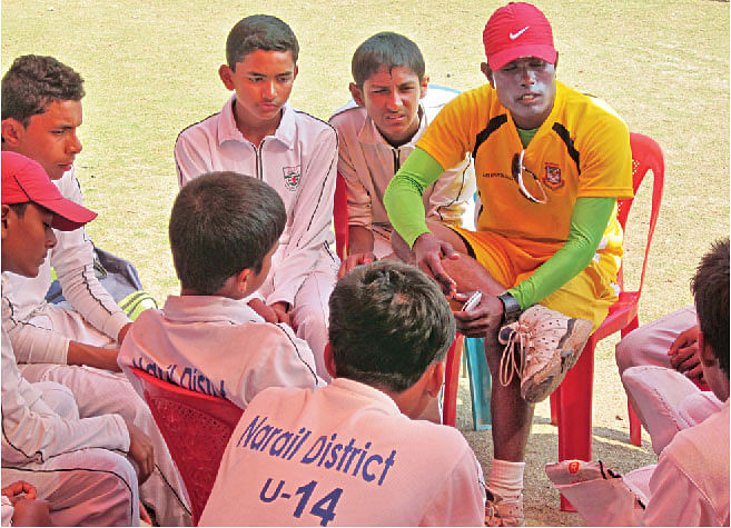 Narail Under 14's cricket coach Md Imrul Kayes gives a pep talk to the team during the lunch break at the Divisional Final.