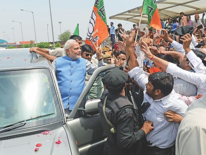 Narendra Modi waves to supporters as he arrives at Indira Gandhi International Airport in New Delhi, yesterday. Photo: AFP