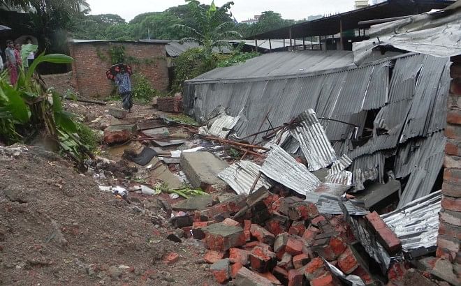 After four days of incessant rain, a boundary wall collapsed on a part of the tin-shed barracks of construction workers in Rahamat Nagar in Nasirabad of Chittagong city yesterday, killing one person and injuring three others. Photo: Anurup Kanti Das