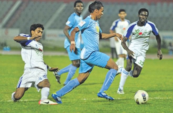 Abahani right-back Nasirul Islam (C) skips past Uttar Baridhara defenders during their 5-2 victory in the Nitol Tata Bangladesh Premier League match at the Bangabandhu National Stadium yesterday. PHOTO: STAR