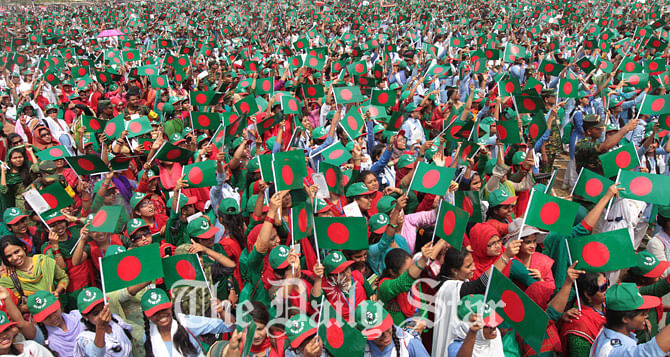 People wave miniature national flag as they gather at National Parade Ground to sing the national anthem together in a bid to set new world record. Photo: Sk Enamul Haq