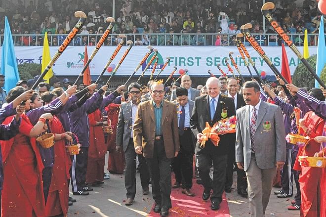 Leandro Negre (2nd R), the president of the International Hockey Federation (IHF) received a colourful welcome from school children as he inaugurated the First Security Islami Bank Limited National School Hockey Tournament at the Maulana Bhasani Hockey Stadium yesterday. Photo: Star