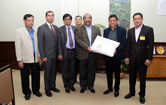 Officials of National Finance Ltd handing over blankets to Bangladesh Bank fund for alleviating the sufferings of the poor during winter. Photo: Courtesy