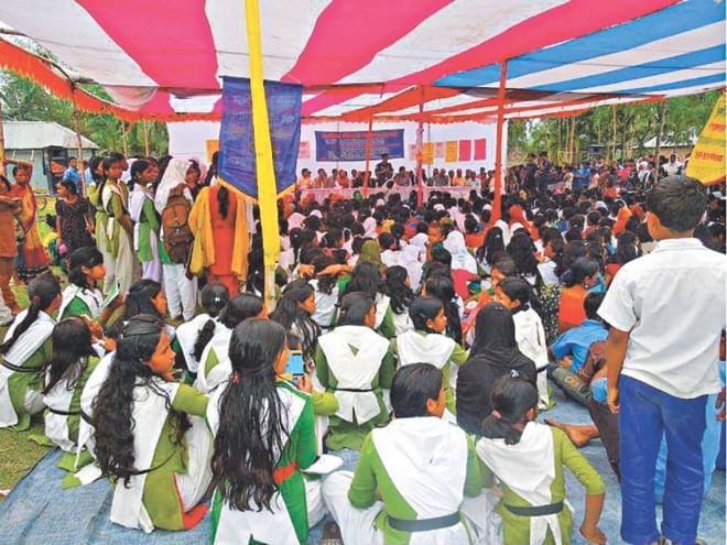 Schoolchildren attend a programme organised by NGO Udayankur Seba Sangstha on the playground of Polashbari Parashmoni High School in Nilphamari Sadar upazila during their class hours yesterday.  PHOTO: STAR