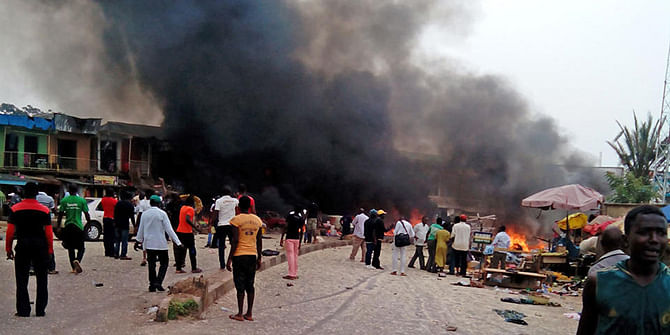 Smoke rises after a bomb blast at a bus terminal in Jos, Nigeria, Tuesday. Photo: AP