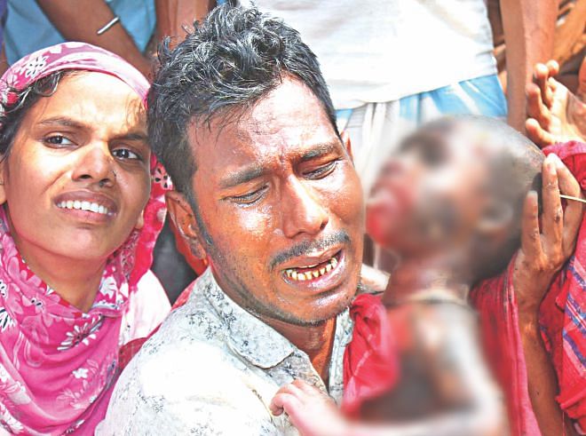 In this photo, partly blurred, a family member weeps holding the charred body of an infant killed at a Bihari camp in Mirpur early yesterday.  Photo: Banglar Chokh