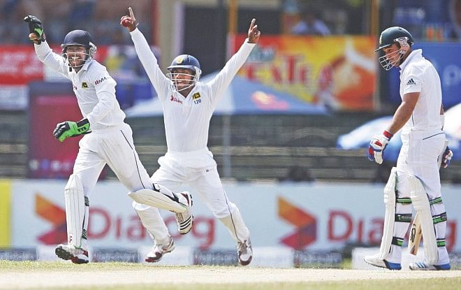 Sri Lanka wicketkeeper Niroshan Dickwella (L) and Kaushal Silva (C) celebrate the dismissal of South Africa's Dean Elgar during the second day of the second Test in Colombo yesterday. PHOTO: REUTERS