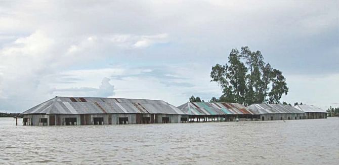Only the top halves of the buildings of Nowkhila PN High School in Shariakandi upazila of Bogra are above the flood-water. The pictures were taken yesterday.  Photo: Star