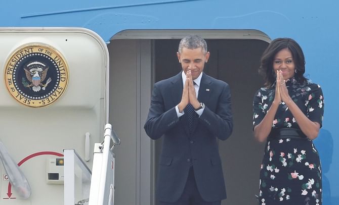Barack and Michelle Obama wave as they leave India. Photo: AFP
