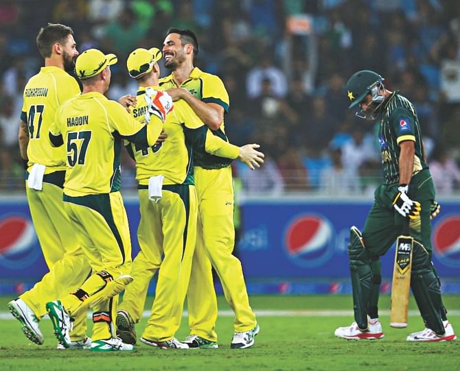 Australia pacer Mitchell Johnson (4th from left) is mobbed by teammates after he removed Shahid Afridi during the second ODI against Pakistan in Dubai yesterday. PHOTO: INTERNET