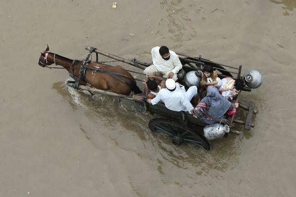A Pakistani family travels on a horse-cart through flood road following heavy rain in Lahore September 4, 2014. 