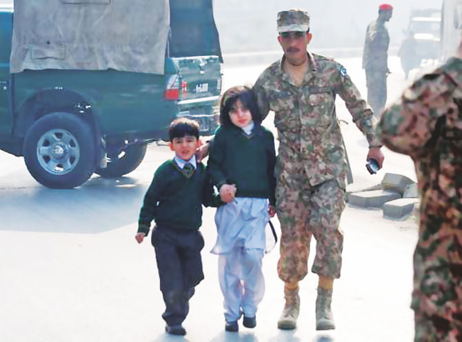 A soldier escorts schoolchildren after they were rescued from the Army Public School that was under attack by Taliban gunmen in Peshawar yesterday. Photo: AFP