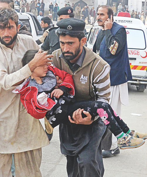 Volunteers carry an injured school girl to a hospital. Photo: AFP