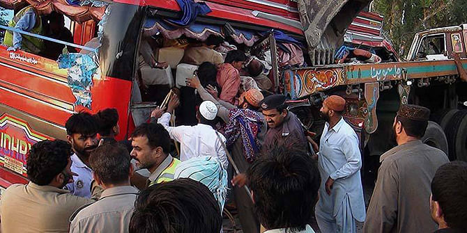 Rescue workers and volunteers gather to remove passengers from a damaged bus at the accident site in Pano Aqil, Pakistan.Photo: AP