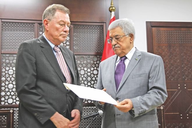 Palestinian president Mahmud Abbas (R) delivers a note to Robert Serry (L), the United Nations Special Coordinator for the Middle East Peace Process, condemning the Israeli assault on Gaza in Ramallah, yesterday. Photo: AFP