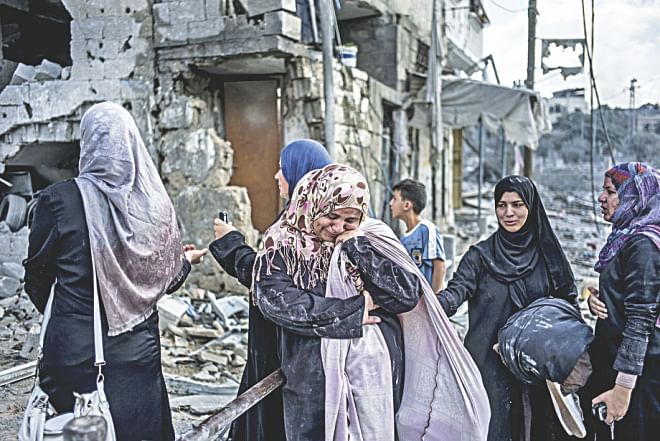 Palestinian women react amid the destruction in the district. Photo: AFP