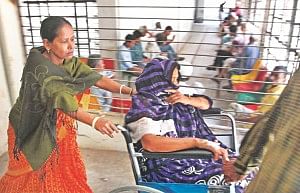 A relative pushing a patient in wheelchair to get services.  Photo: Anurup Kanti Das