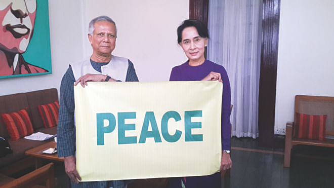 Nobel peace laureates Professor Muhammad Yunus and Aung San Suu Kyi hold up a peace sign together, as their message to the world during their meeting in Yangon, Myanmar on Saturday. Photo: Yunus Centre