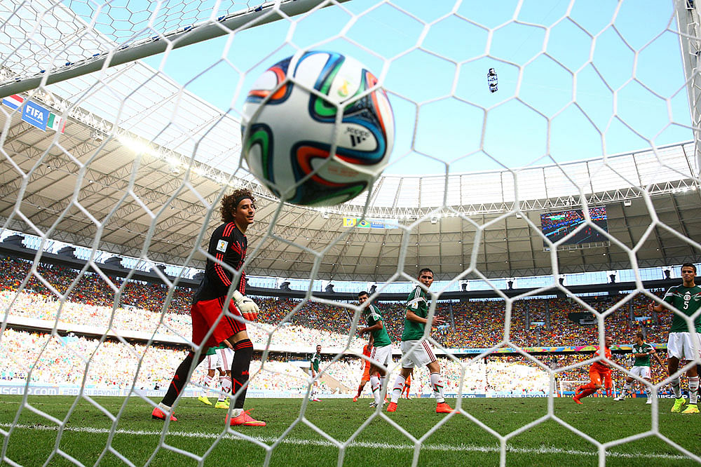 Wesley Sneijder of the Netherlands scores his team's first goal past Guillermo Ochoa of Mexico during the 2014 FIFA World Cup Brazil Round of 16 match between Netherlands and Mexico. Photo: Getty Images