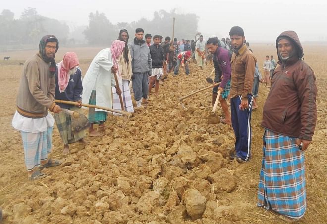 People of Protapi village in Komolganj upazila of Moulvibazar join hands to renovate the road in their area as the authorities concerned did not take any step in this regard despite several pleas in the last two years. PHOTO: STAR