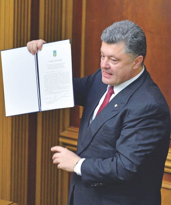 Petro Poroshenko shows a newly voted Ukrainian law about the ratification of the Ukraine-EU association agreement at the Ukrainian Parliament in Kiev, yesterday.  Photo: AFP