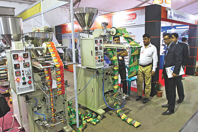 Visitors look at an automatic food packaging machine at a stall at the Dhaka International Plastic, Packaging, and Printing Industrial Fair at Bangabandhu International Conference Centre in the capital yesterday. Photo: Star
